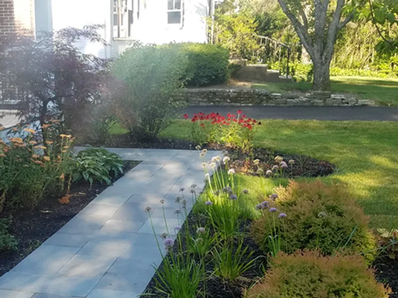 Bluestone front walkway bordered by lush garden plantings