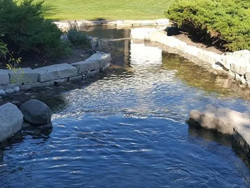 Natural stone stream and waterfall winding through a backyard
