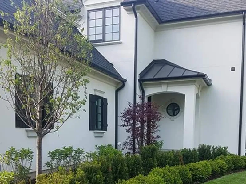 Columned front porch framed by manicured foundation plantings